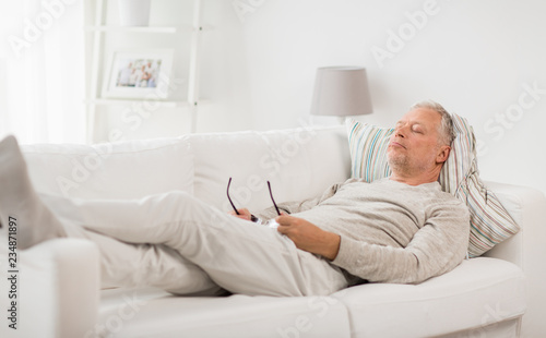 old age, rest, comfort and people concept - senior man sleeping on sofa at home © Syda Productions