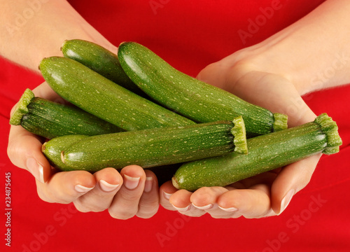 WOMAN HOLDING BABY COURGETTES / ZUCCHINI