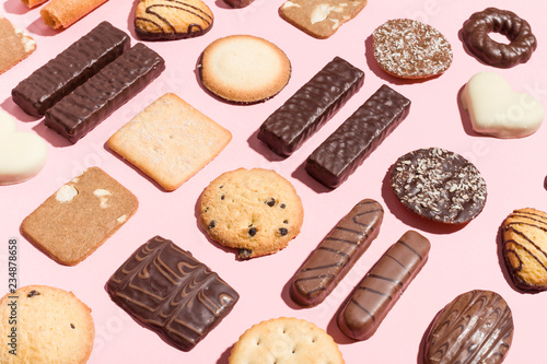 Variety of traditional cookies arranged geometrically on pink background