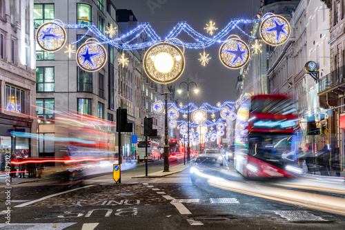 London im Winter bei Nacht: weihnachtlich geschmückte Einkaufstraße mit vorbeifahrenden Bussen