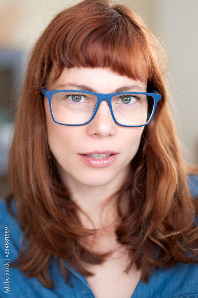 Porträt einer coolen rothaarigen Frau mit Brille