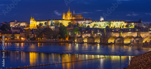 Prague - The Charles Bridge, Castle and Cathedral from promenade over the Vltava river at dusk.