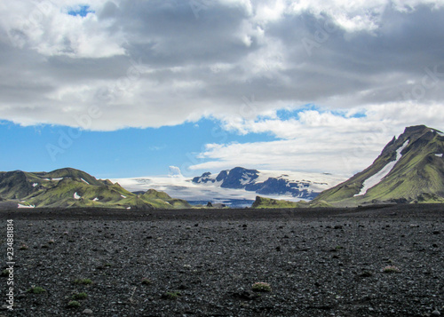 Landscape of Maelifellsandur volcanic black sand desert with Myrdalsjokull glacier and blue sky, summer in Highlands of Iceland photo