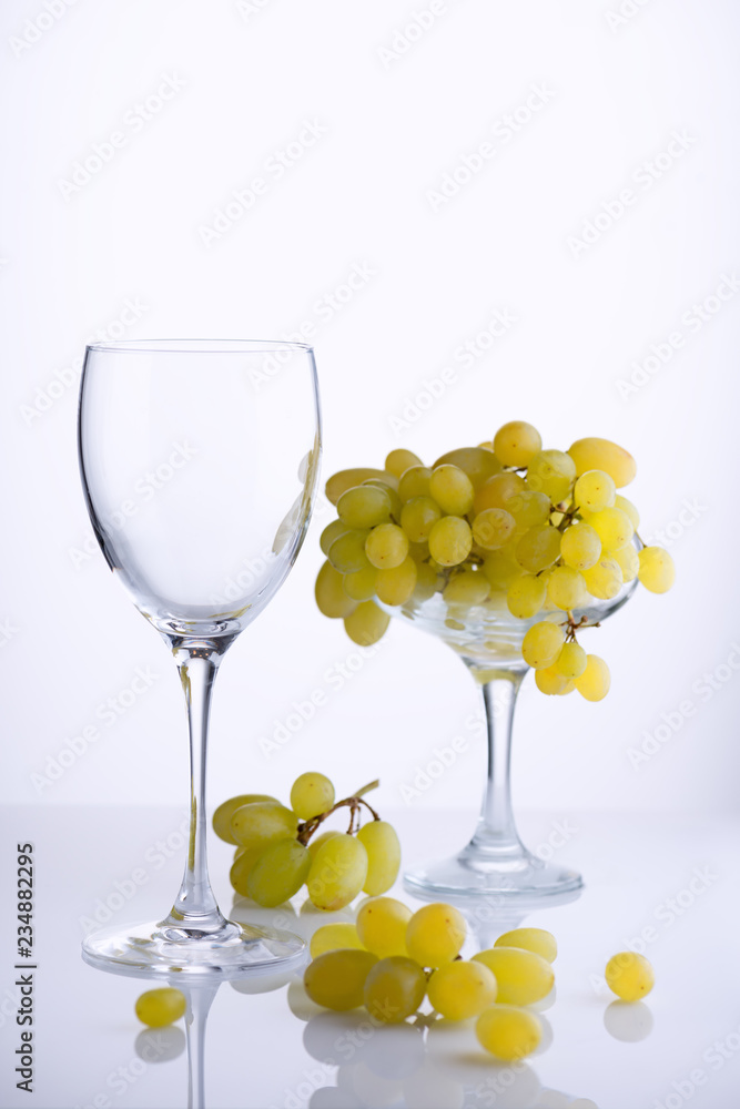 Glass and a bunch of ripe grapes on white background Glass and a bunch of ripe grapes on white background