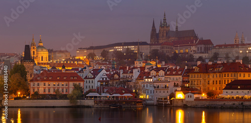 Prague - The Mala Strana, Castle and Cathedral from promenade over the Vltava river at dusk.