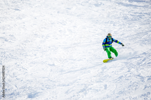 Photo of sports man snowboarding on snowy slope