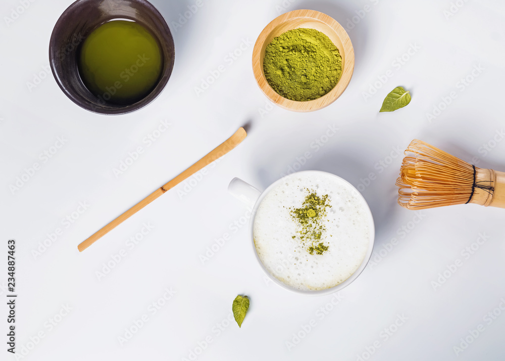 Matcha latte in a cup, powder and tools for making tea on the white background,
