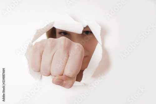 woman punching hole through paper wall with fist