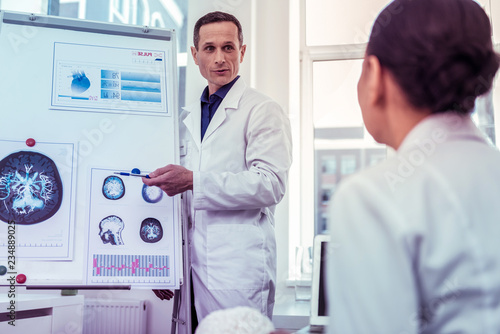 Handsome doctor standing near board for presentations