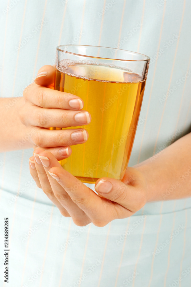 WOMAN HOLDING GLASS OF APPLE JUICE WOMAN HOLDING GLASS OF APPLE JUICE
