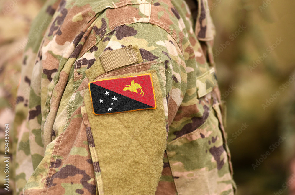 Fototapeta premium Papua New Guinea flag on soldiers arm. Papua New Guinea troops (collage)