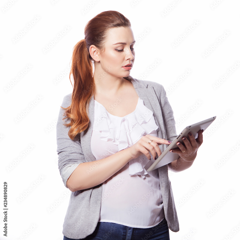 Brunette plus size woman in smart casual outfit (jacker and blouse) on an isolated white background. She holds gadgets in ger hands: tablet and phone. Freelance business concept: work in internet,SMM. Brunette plus size woman in smart casual outfit (jacker and blouse) on an isolated white background. She holds gadgets in ger hands: tablet and phone. Freelance business concept: work in internet,SMM.