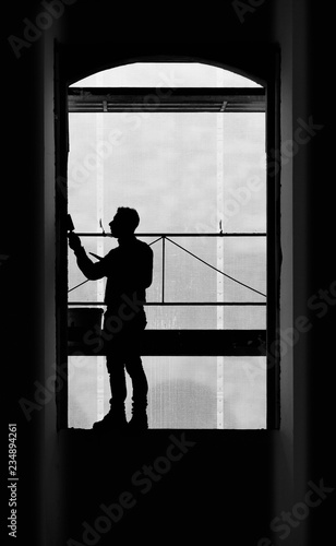 Worker balancing on a window while working