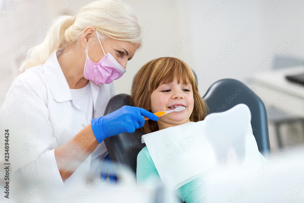 Female dentist and her child patient Female dentist and her child patient