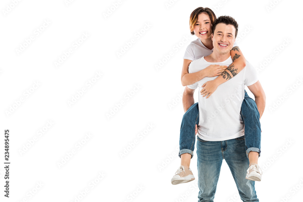 happy husband giving piggyback ride to wife isolated on white