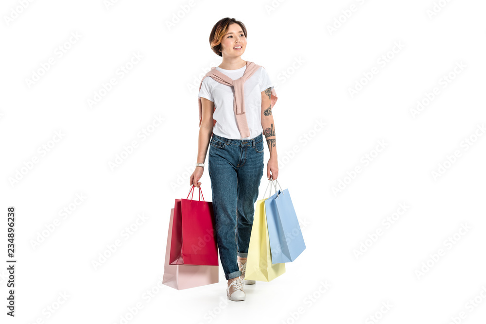 smiling young woman holding shopping bags isolated on white
