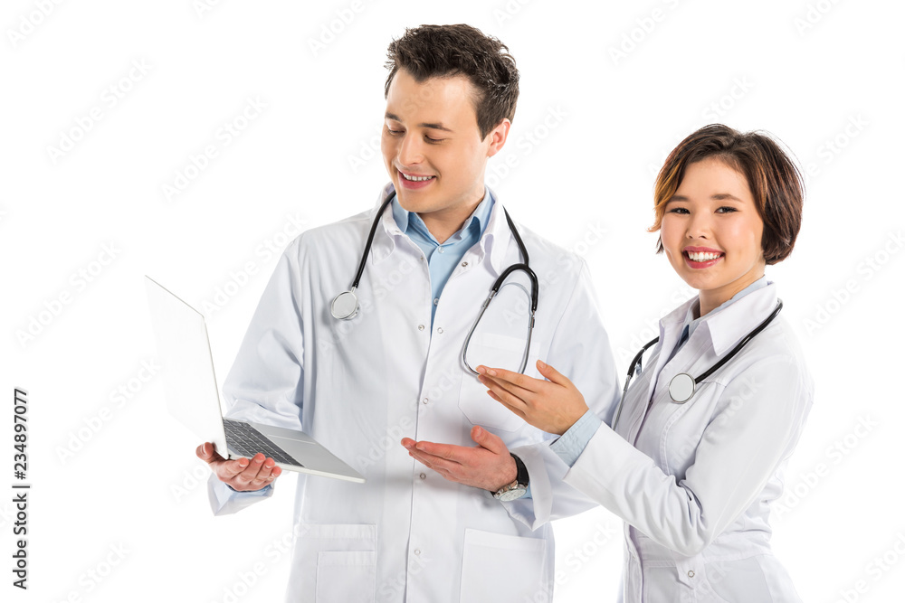 smiling female and male doctors using laptop isolated on white smiling female and male doctors using laptop isolated on white