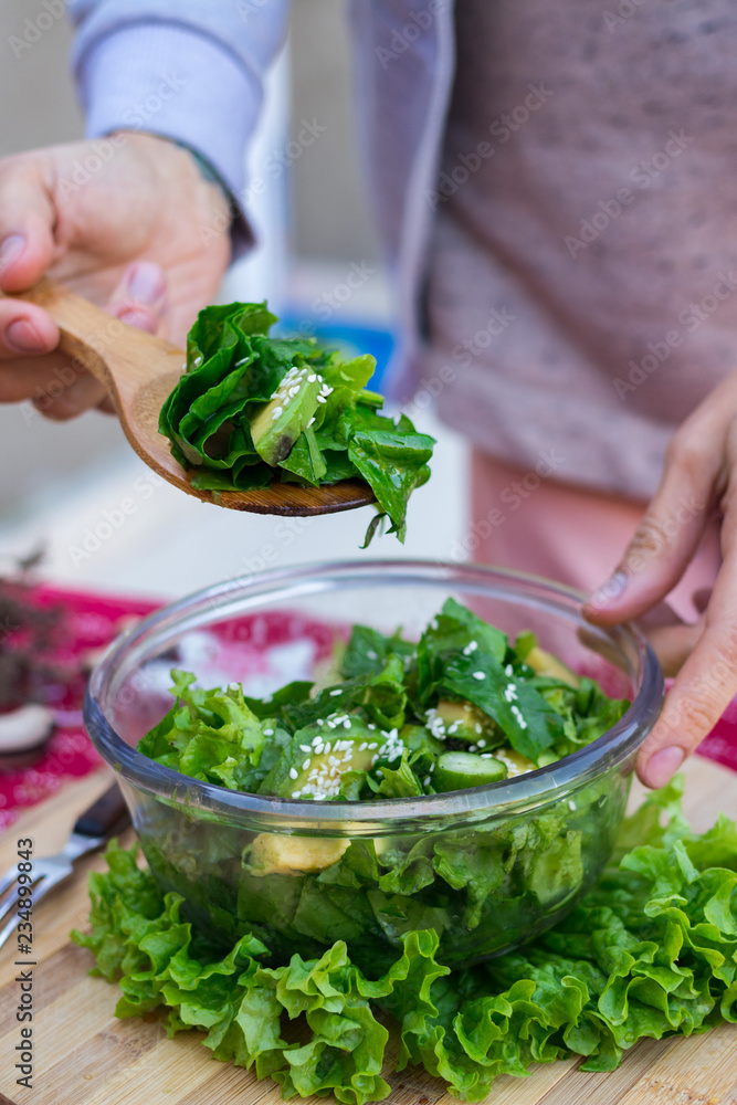 Spinach avocado fresh salad with Christmas red stars. Christmas food on red teblecloth