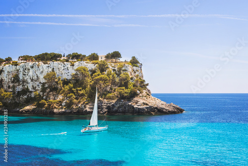 Beautiful bay with sailing boat yacht, Cala Galdana, Menorca island, Spain. Yachting, travel and active lifestyle concept