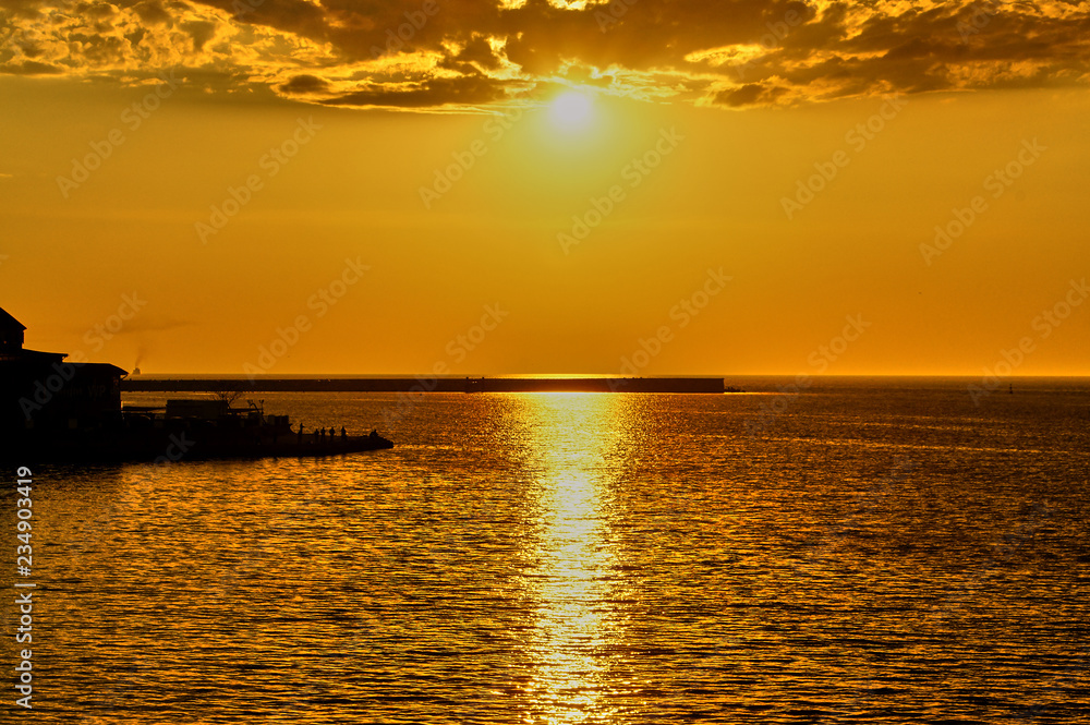 Sunset over the sea in the bay of Sevastopol. The sun sets in the sea..The golden reflection of sunlight on the sea surface. Calm sea without excitement. nature concept for design.