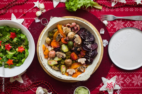 Baked, roasted, grilled vegetables in skillet pan. Beetroot, carrot, mushrooms, pumpkin, brussels sprouts with avocado dpi sauce. Vegan lunch, vegetarian dinner, healthy Christmas food