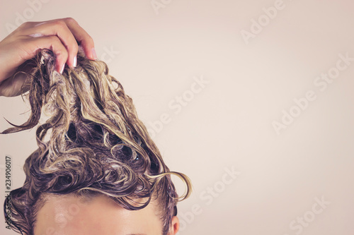 Funny woman pulls himself wet hair up. Close-up, space for text. Hair care concept