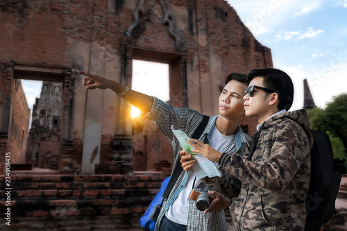 Two Asian men travelers looking map at a temple ,what are the attractions location in the map..