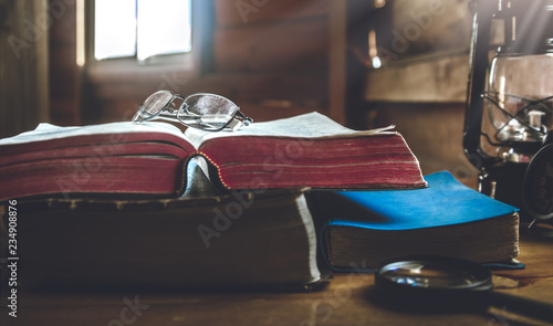 eyeglass on holy Bible with window light in morning. photo