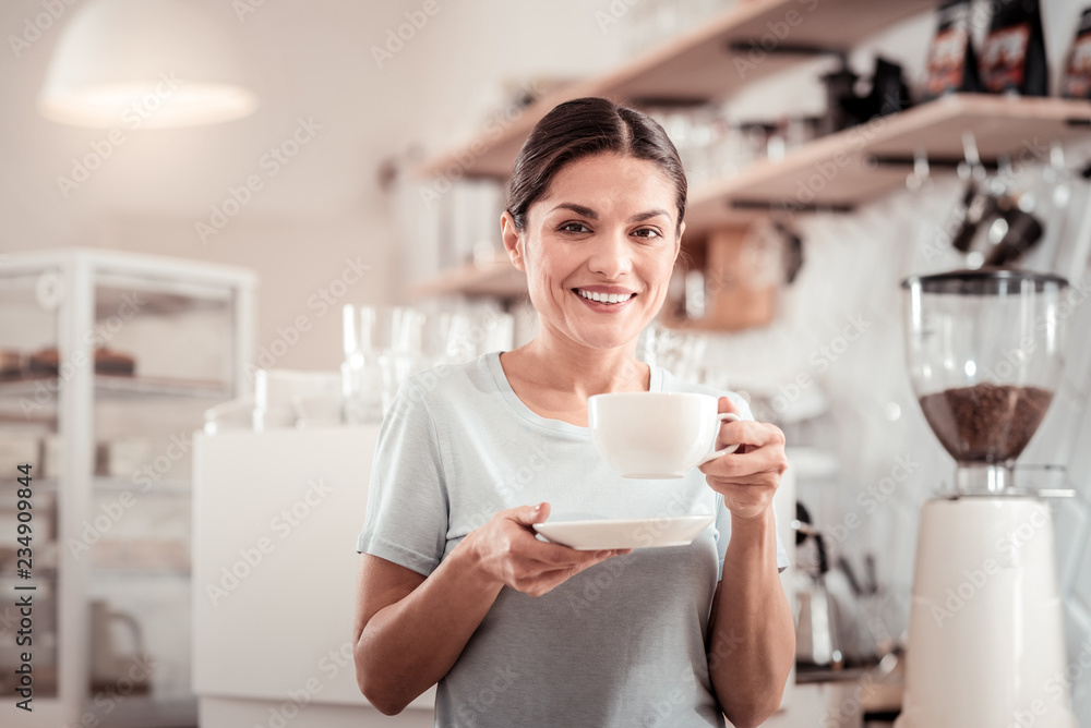 Delighted positive woman enjoying her coffee Delighted positive woman enjoying her coffee