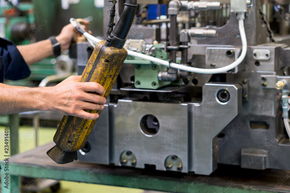 Worker moving high precision die mold for casting automotive aluminium parts with overhead crane in the factory Worker moving high precision die mold for casting automotive aluminium parts with overhead crane in the factory