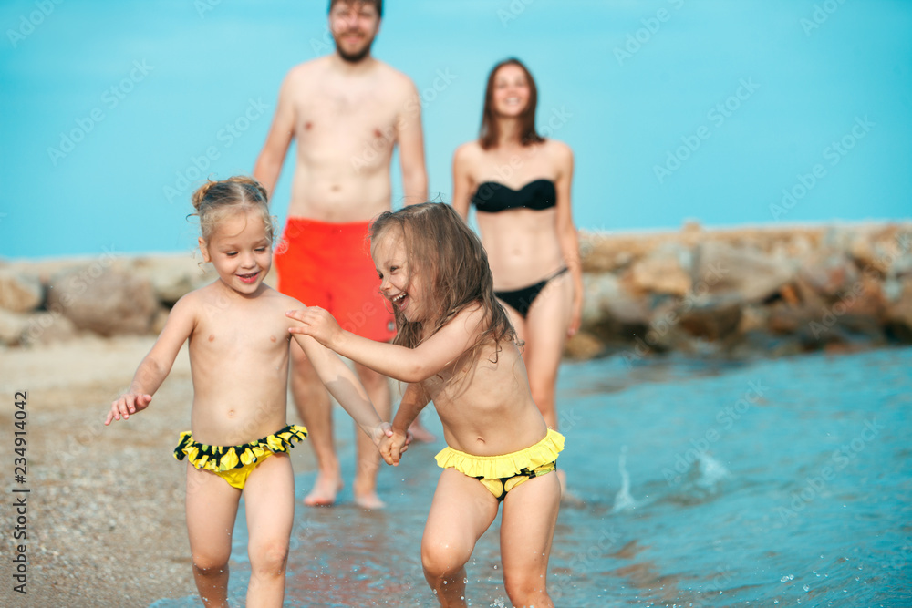 Happy family enjoying walk on the sea beach. The summer, childhood, holiday, leisure, lifestyle, travel, vacation concept Happy family enjoying walk on the sea beach. The summer, childhood, holiday, leisure, lifestyle, travel, vacation concept