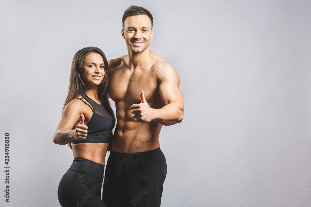 Athletic man and woman isolated over white background. Personal fitness instructor. Personal training. Thumbs up.