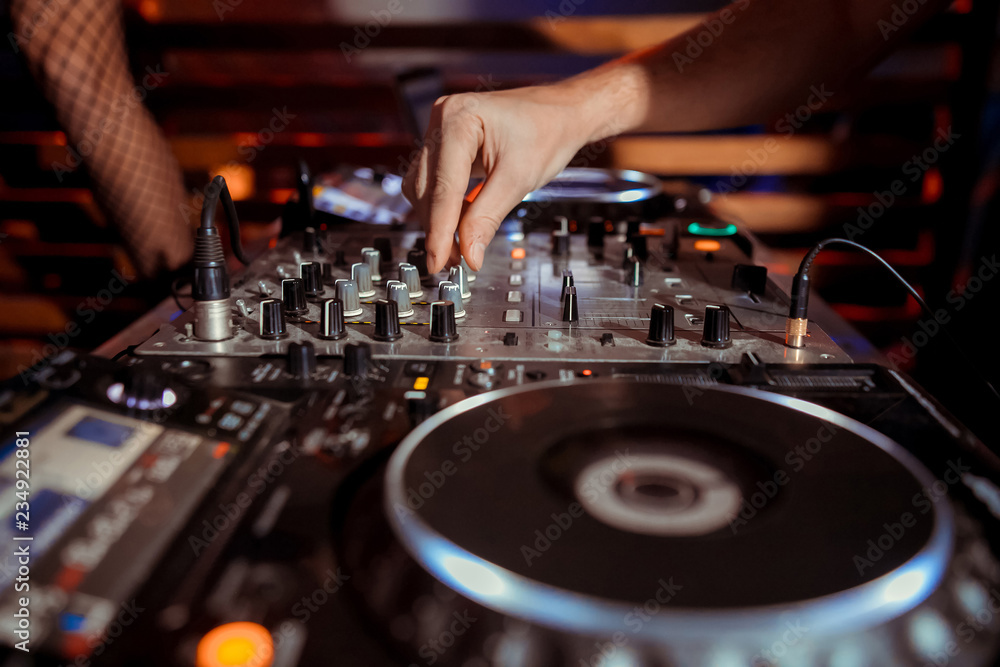 Dj playing the track in the nightclub at party closeup Dj playing the track in the nightclub at party closeup