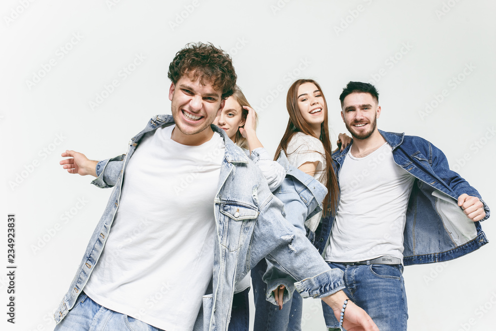Group of smiling friends in fashionable jeans. The young men and woman  posing at studio. The fashion, people, happy, lifestyle, clothes concept  Stock Photo | Adobe Stock