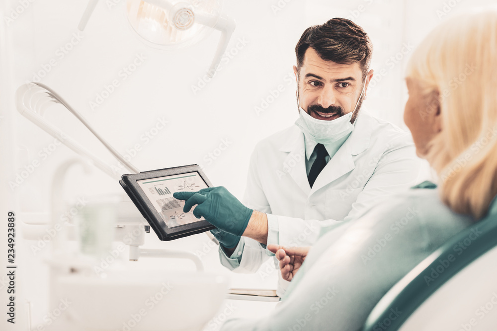 Dentist holding tablet and talking with patient Dentist holding tablet and talking with patient