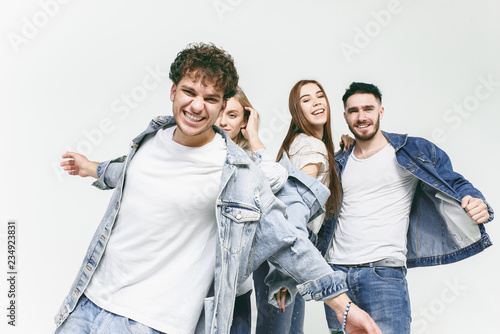 Group of smiling friends in fashionable jeans. The young men and woman posing at studio. The fashion  people  happy  lifestyle  clothes concept