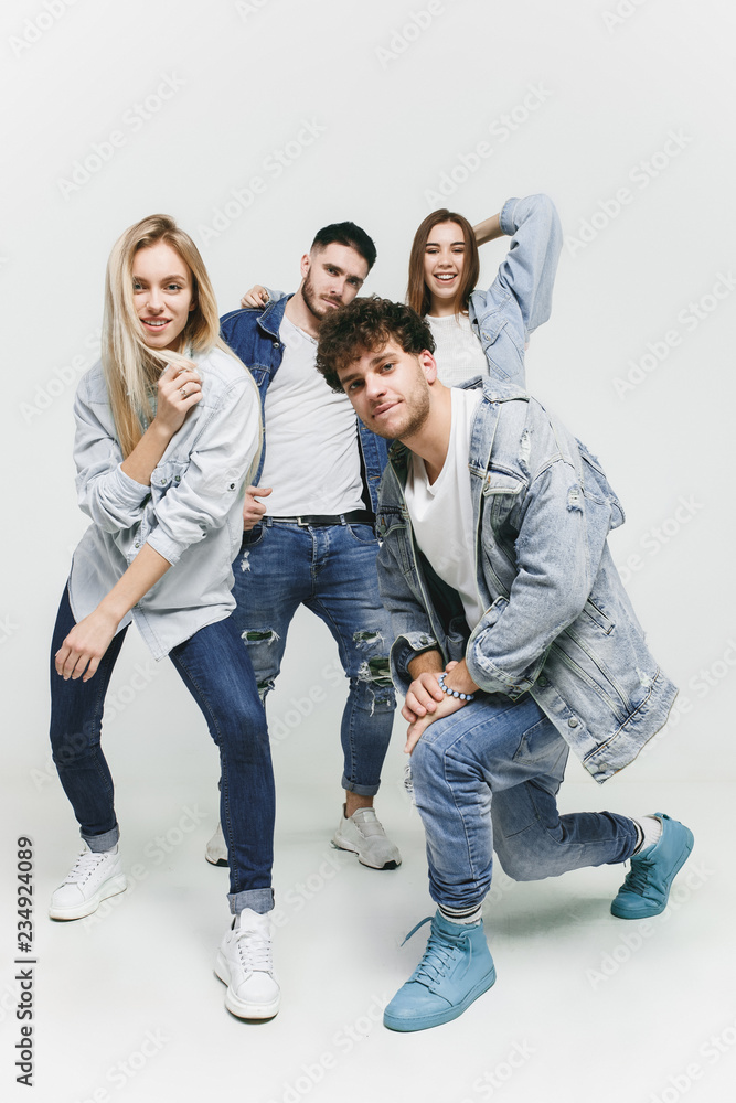 Group of smiling friends in fashionable jeans. The young men and woman  posing at studio. The fashion, people, happy, lifestyle, clothes concept  Stock Photo | Adobe Stock