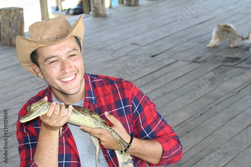 Zookeeper enjoying work with a baby caiman 