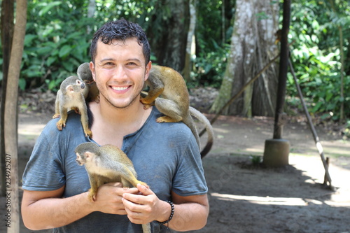 Young ethnic man living with a group of monkeys