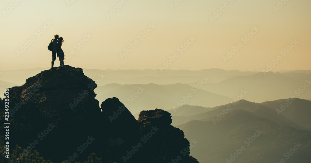 Fototapeta premium Silhouette of couple on top of mountain