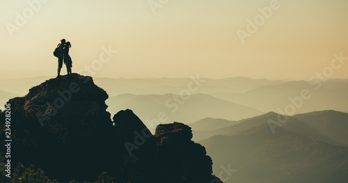 Silhouette of couple on top of mountain