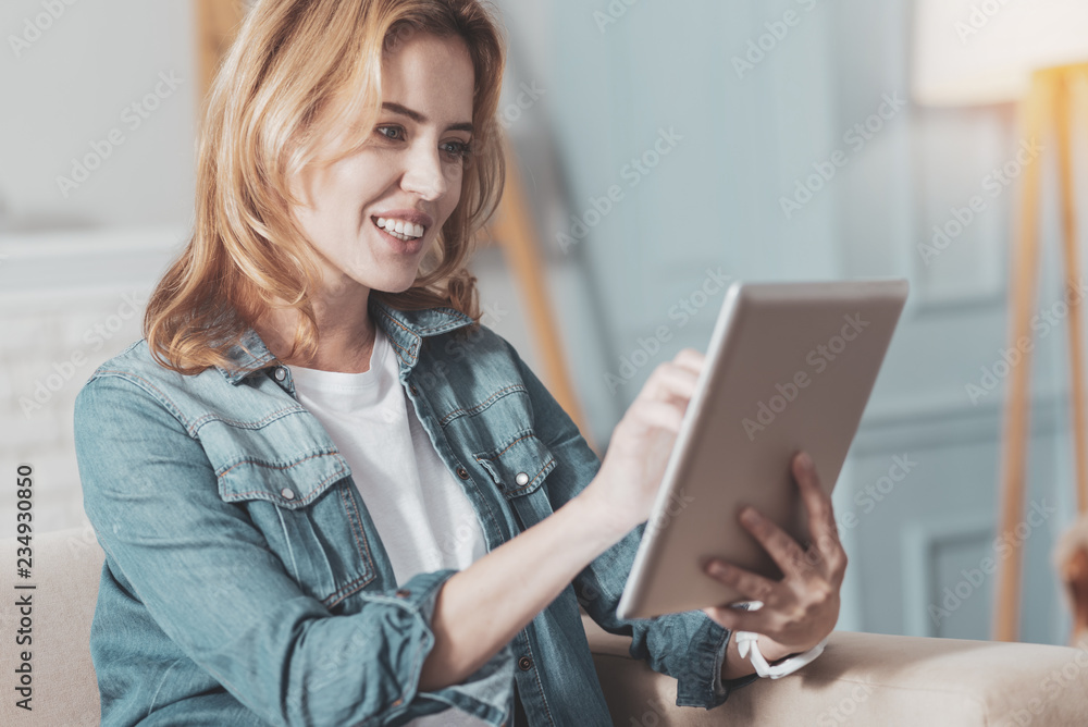 Nice positive woman holding a tablet