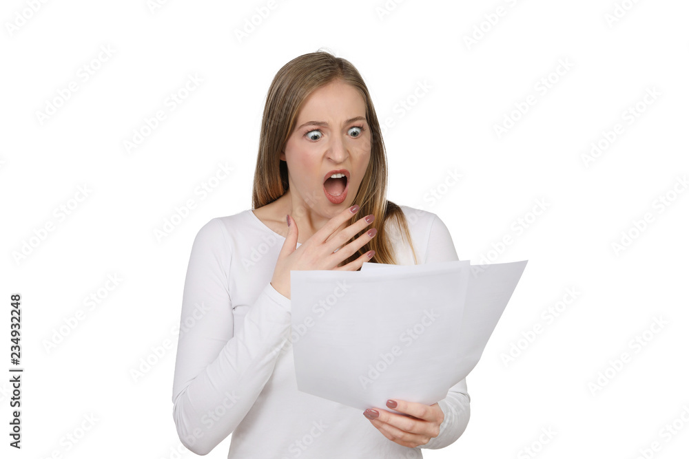 Frau schaut erschrocken auf Papiere in ihrer Hand Frau schaut erschrocken auf Papiere in ihrer Hand