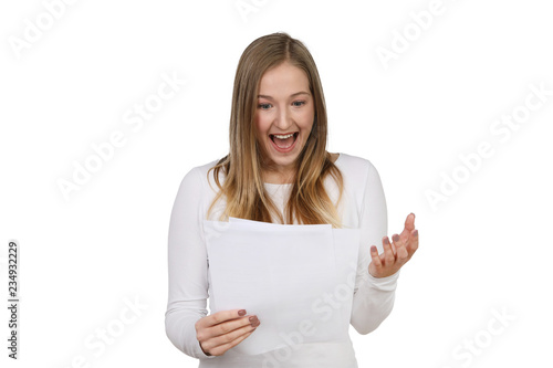 Junge Frau schaut freudig auf ein Schreibenin ihren Händen
