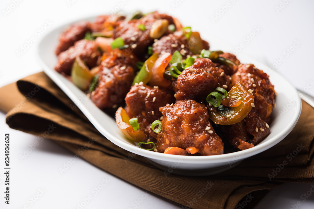 Indian Chilli Chicken dry, served in a plate over moody background. Selective focus Indian Chilli Chicken dry, served in a plate over moody background. Selective focus