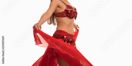 Beautiful belly dancer young woman in gorgeous red and gold costume dress. Part of body