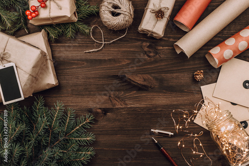 Holiday flatlay arrangement of wrapped presents on dark wooden background with copyspace