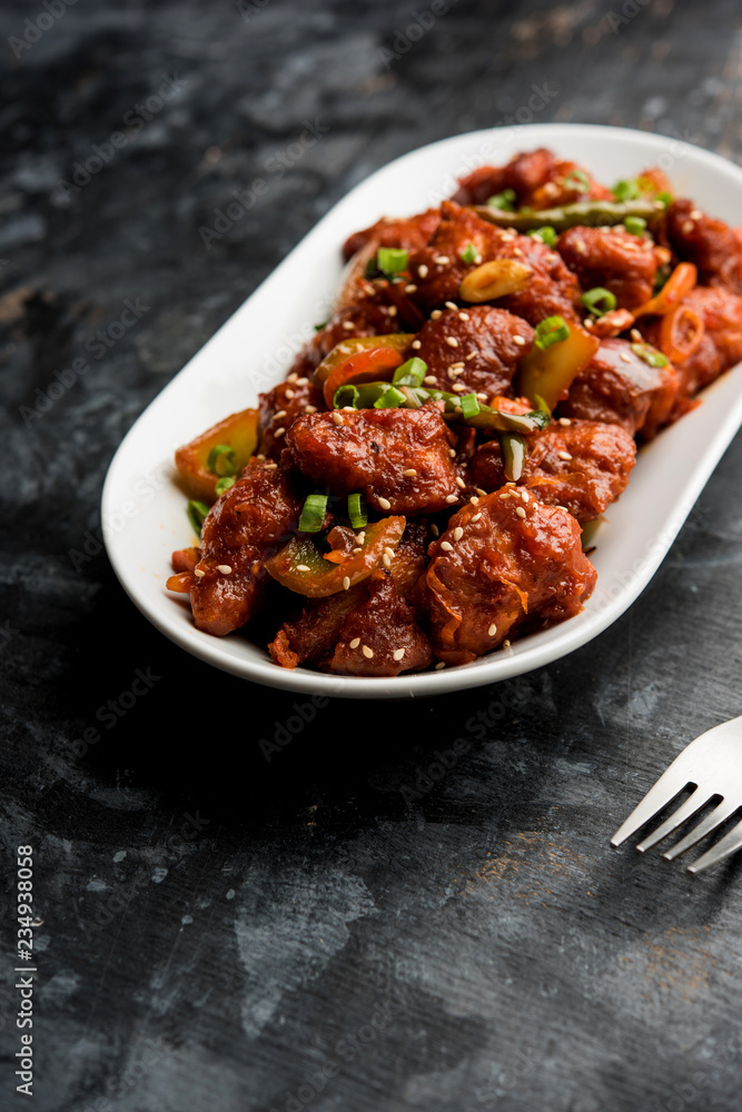 Indian Chilli Chicken dry, served in a plate over moody background. Selective focus Indian Chilli Chicken dry, served in a plate over moody background. Selective focus