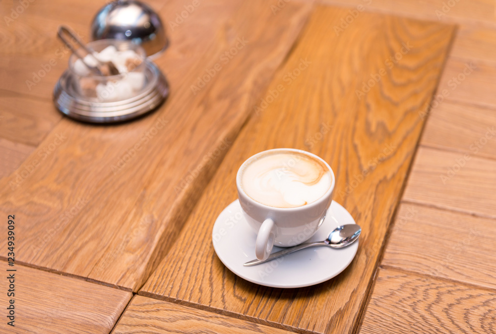 Obraz premium Cup of coffee on a wooden table, sugar bowl, cappuccino