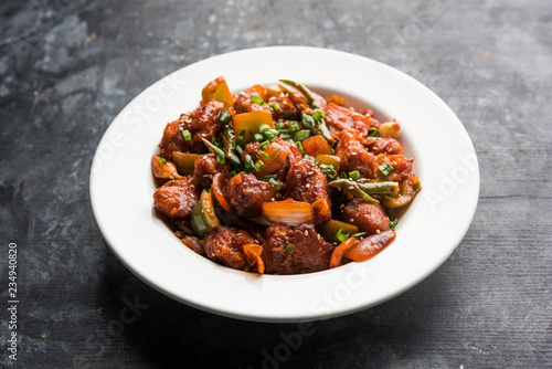 Indian Chilli Chicken dry, served in a plate over moody background. Selective focus